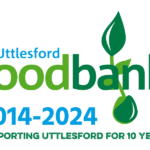 Uttlesford Foodbank Logo. The words Uttlesford Foodbank in blue and green. The letter a has an apple growing underneath and a leaf on top. The words 2014-2024 Supporting Uttlesford for 10 years in below this. The image has a white background.